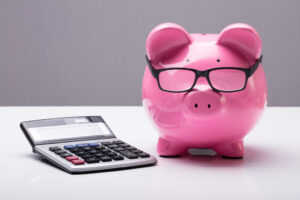 A stylized image of a piggy bank with glasses and a calculator, likely used to illustrate financial concepts related to retirement planning.