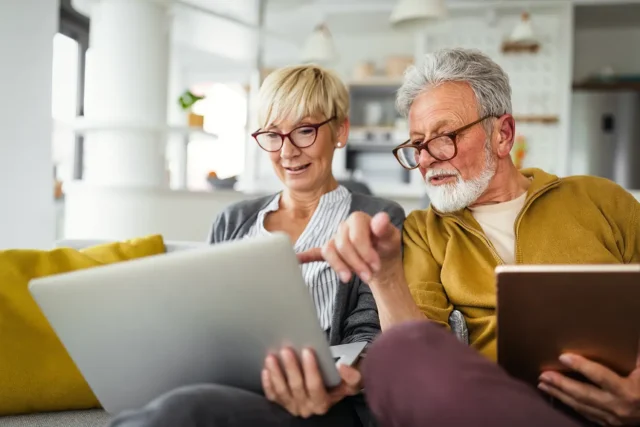 Senior couple reviewing retirement savings plan on a laptop at home.