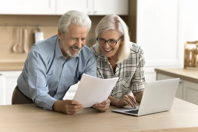 Senior couple analyzing financial documents together at home.